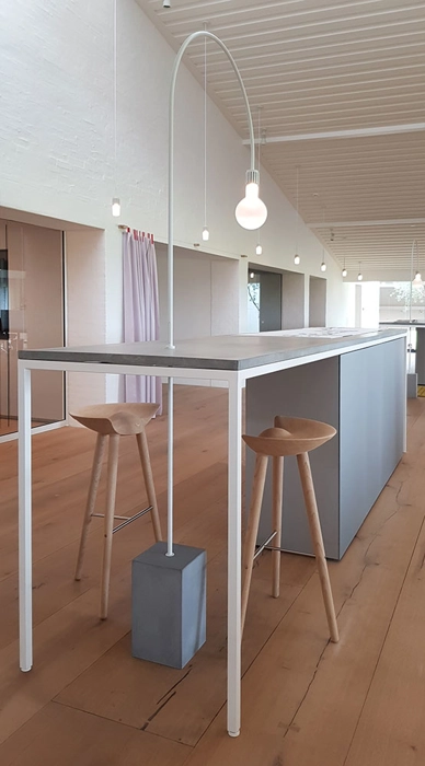 langbord med beton bordplade og eluxeret aluminium skabe og i smuk harmoni med Dinesen heartoak gulv