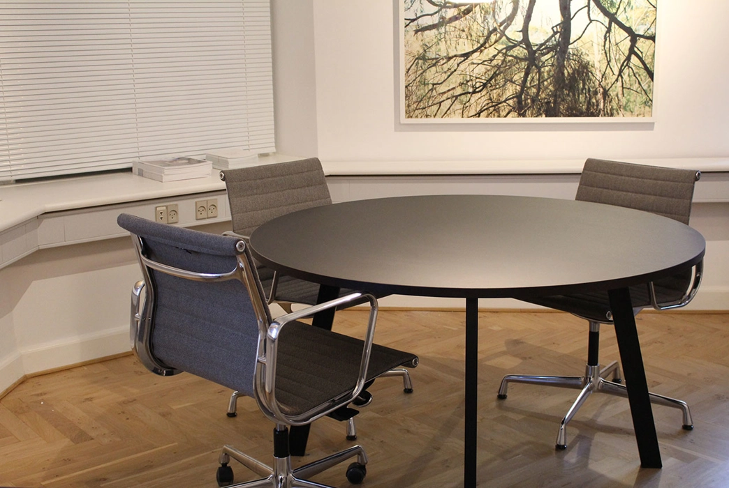Rundt mødebord udført i sort linoleum, med ben i sort lakeret stål, mål efter ønske.