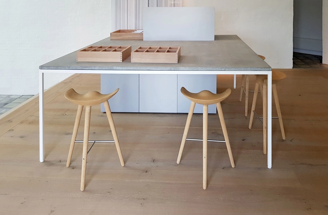 bord med beton bordplade og eluxeret aluminium og i smuk harmoni med Dinesen heartoak gulv